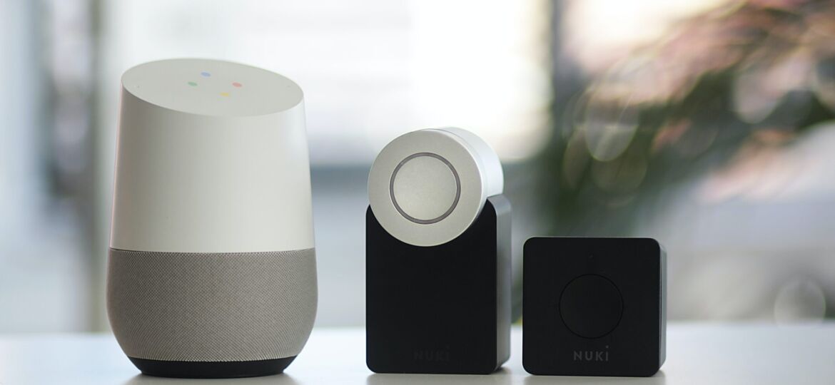 white and gray Google smart speaker and two black speakers