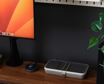 a desk with a laptop, keyboard, mouse and a monitor