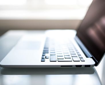 Free Elegant side view of a laptop on a glossy table with natural lighting indoors. Stock Photo