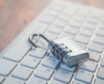 A combination lock rests on a computer keyboard.