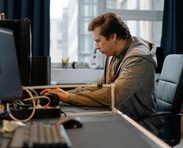 Free A concentrated professional working at a computer in a modern office setting. Stock Photo