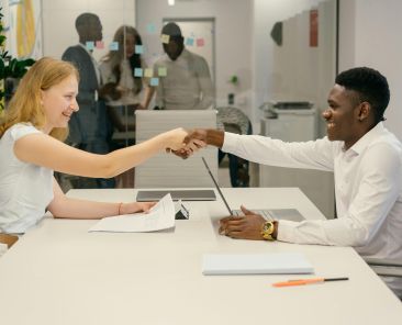 Free Business professionals completing a successful deal with a handshake in a modern office setting. Stock Photo