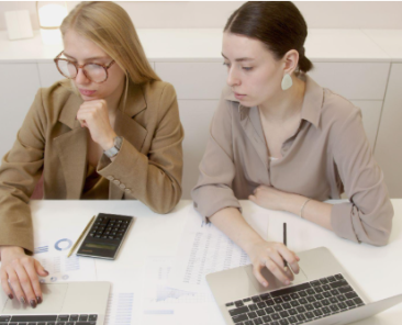 two women with laptops
